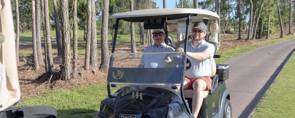 golfers in cart during company round of golf