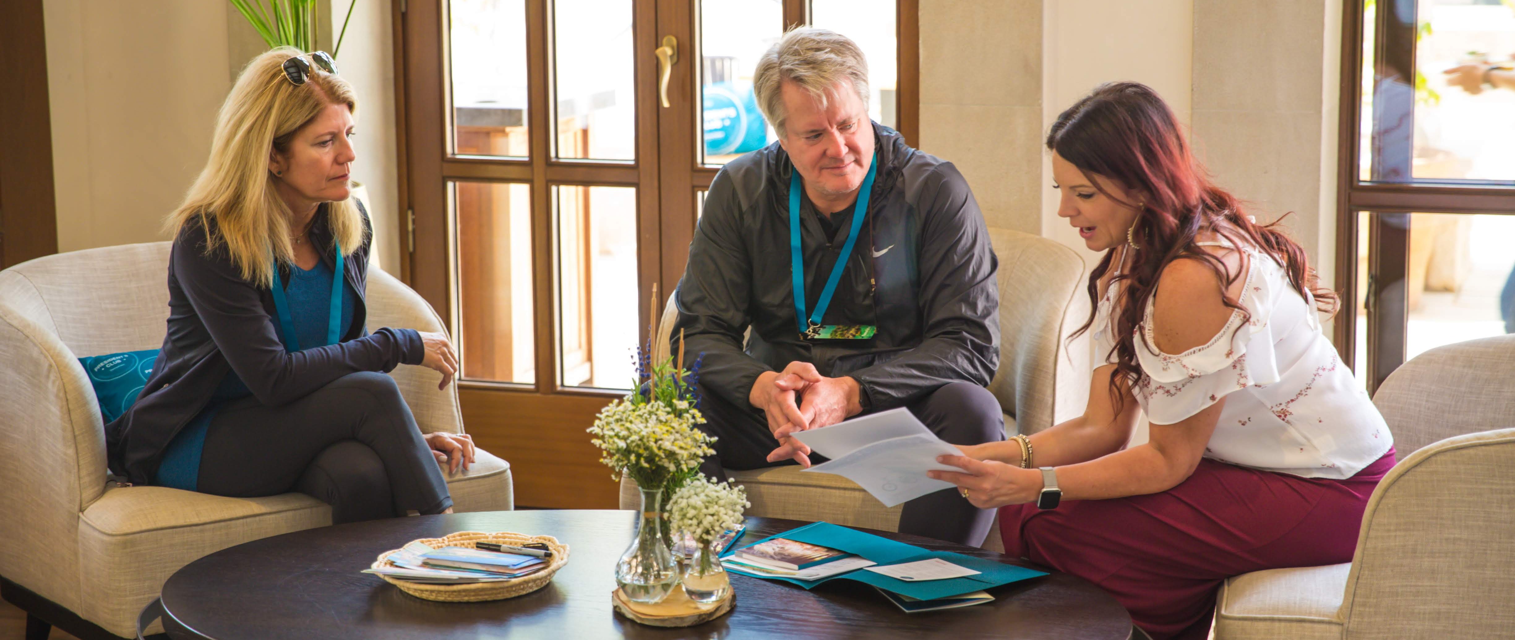 woman chatting with two event attendees during event registration