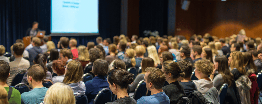 group of event attendees watching a conference presentation