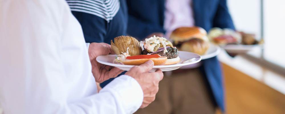 event attendee assembling a lunch burger plate