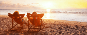 two people lounging on a beach enjoying the sunset at a company retreat