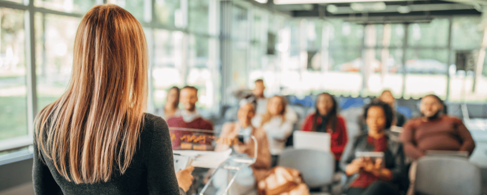 woman giving a presentation to a group of event attendees