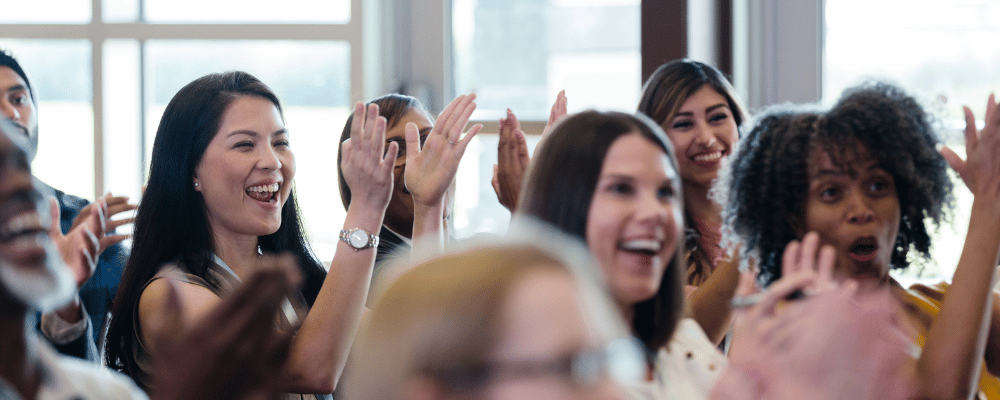 group of event attendees clapping during a conference