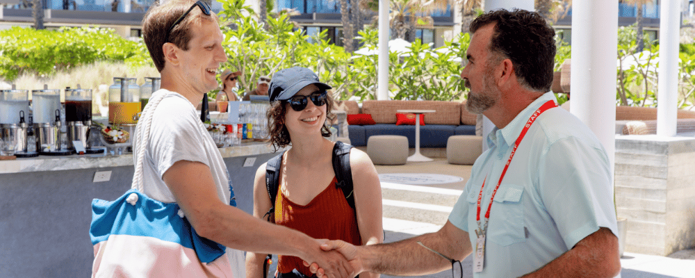 event manager shaking hands with attendees at an incentive travel event in Mexico