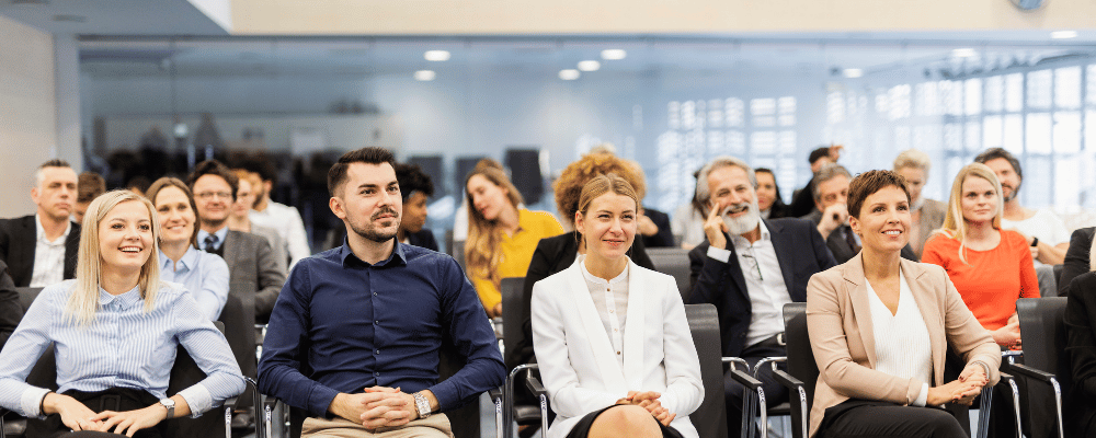 group of event attendees listening to an event presentation at a conference