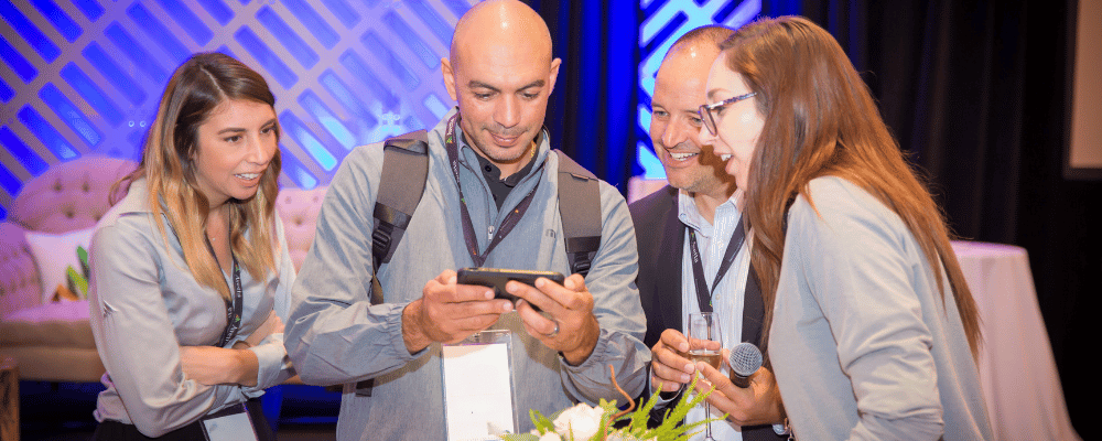 group of event attendees checking a cell phone