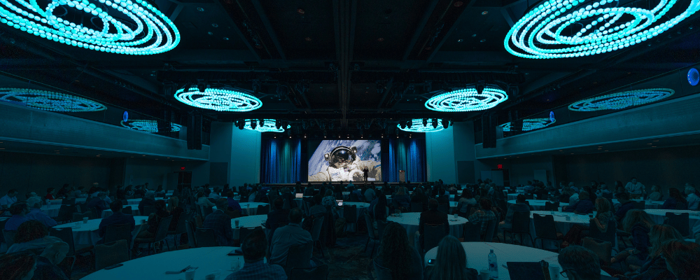 group of gen Z conference attendees watching a corporate conference presentation