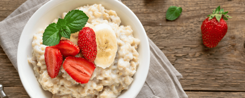 a bowl of warm oatmeal with strawberries and bananas on top
