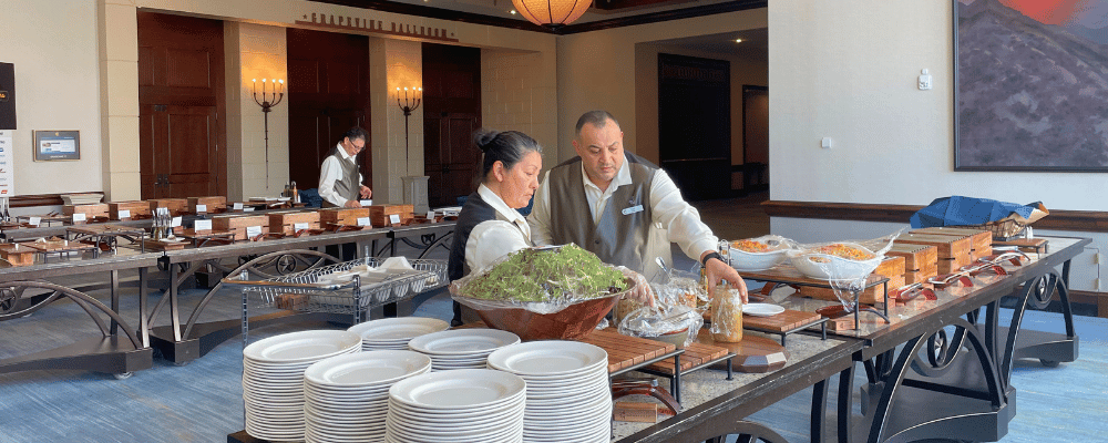 two corporate event caterers arranging the conference food lunch table