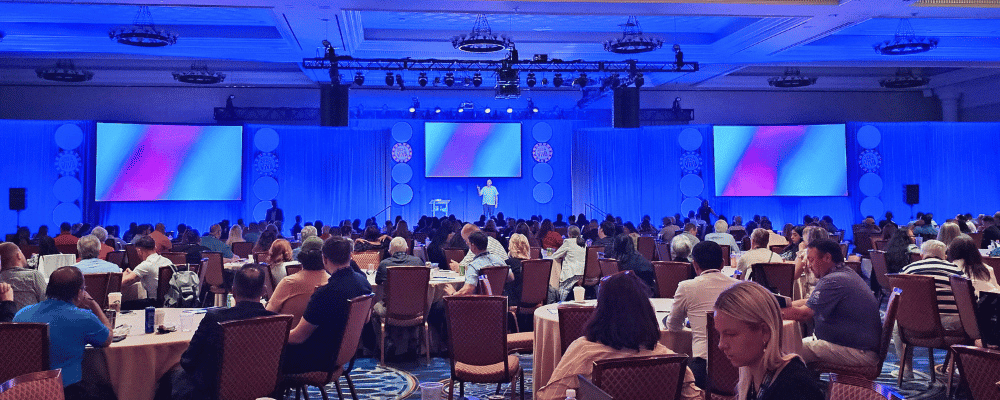 group of attendees watching a presentation with title ' let's plan your best event yet'