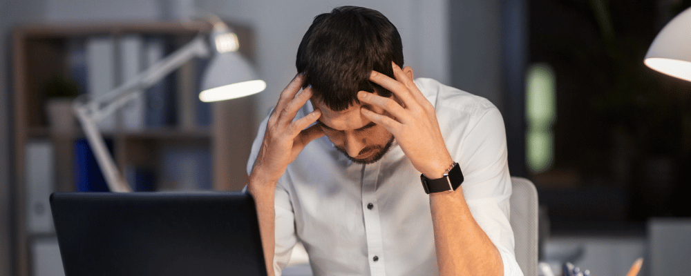 man frustrated while reading his computer 