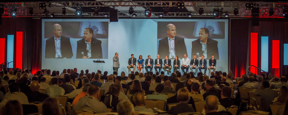 group of attendees watching a panel interview at an international conference