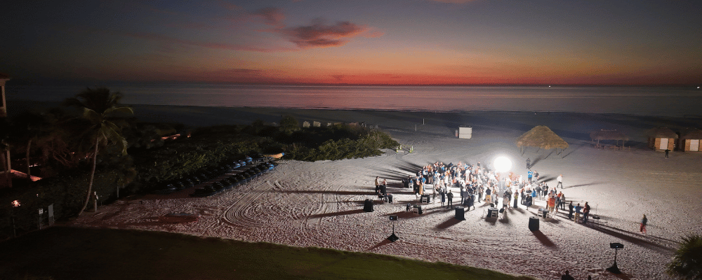 group of attendees networking on the beach