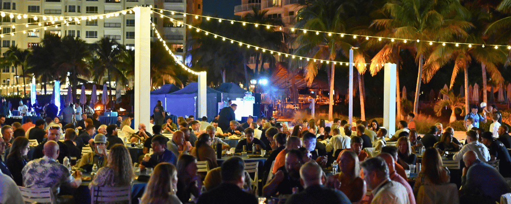 group of attendees having dinner on the beach