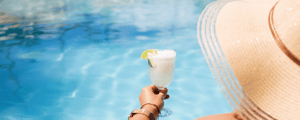 woman holding a drink by the pool at an all-inclusive resort