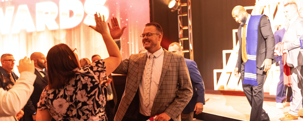 two attendees high fiving during an awards dinner