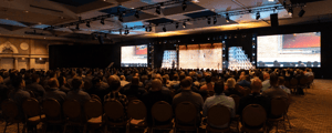 group of attendees watching a corporate conference presentation