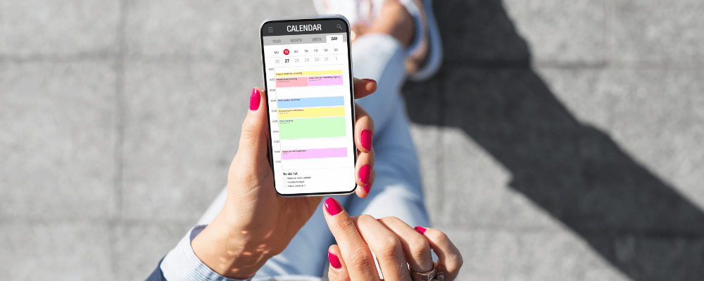 person viewing calendar on their phone with various meetings integrated with event planning app