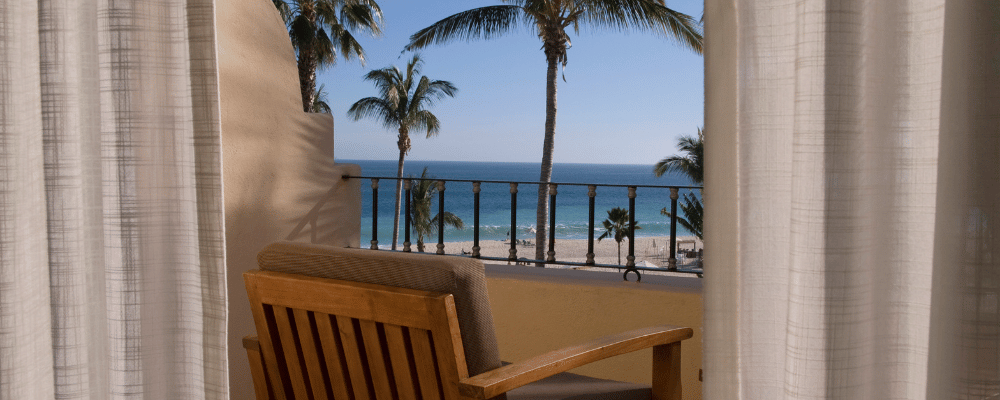 Chair on balcony overlooking beach and ocean on company retreat