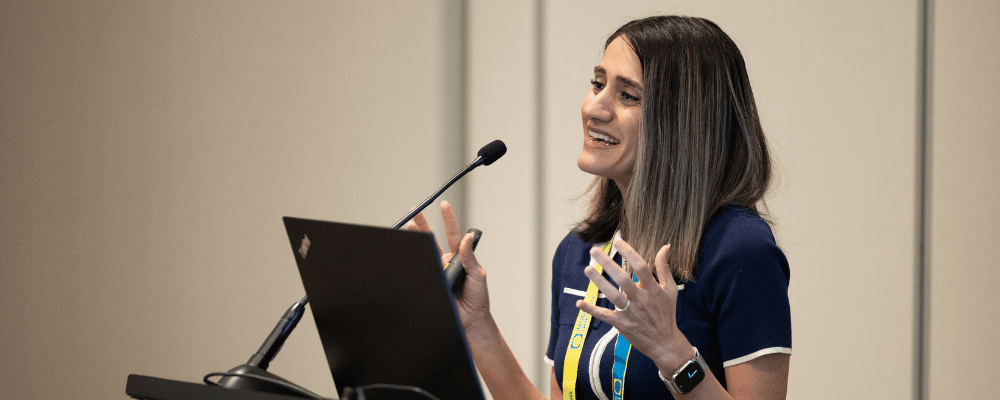 woman giving a speech at a conference