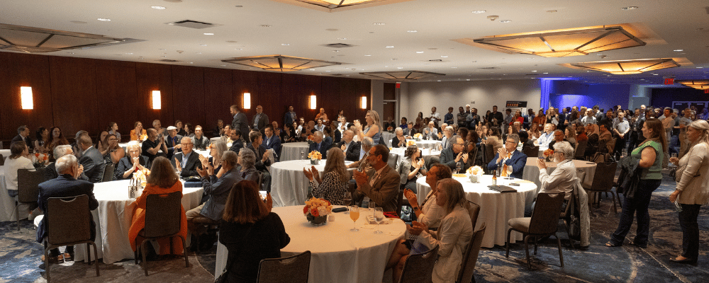 group of event attendees applauding a conference presentation