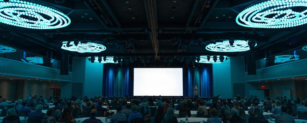 conference stage with attendees watching presentation