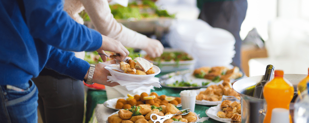 man plating food at an conference event buffet