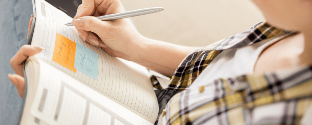 woman writing in notebook following this conference planning guide