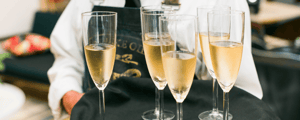 server holding a tray of champagne flutes