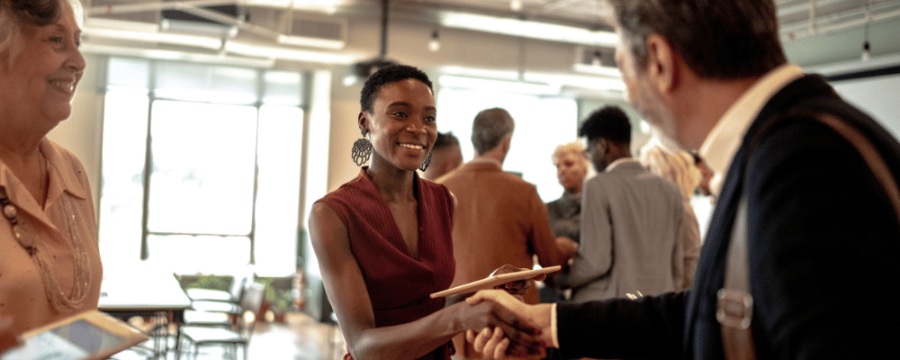 two attendees shaking hands during a corporate conference event