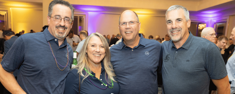 four event attendees smiling during a conference