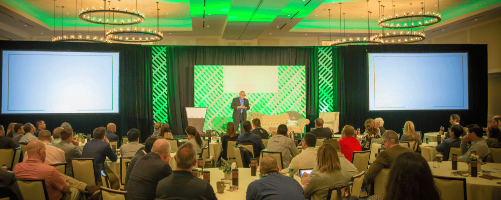 man standing on stage presenting during a conference