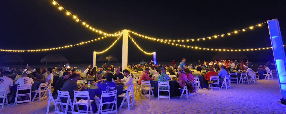 group of incentive trip attendees having dinner on the beach