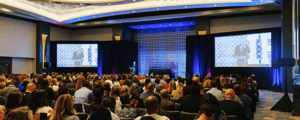 group of attendees watching a corporate meeting presentation