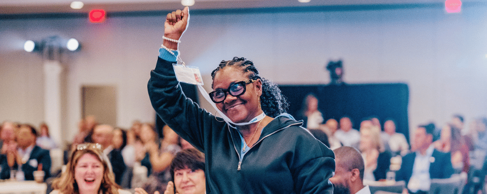 attendee raising her hand during a conference