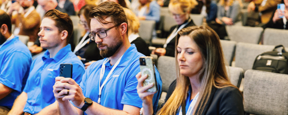 two attendees videotaping a conference