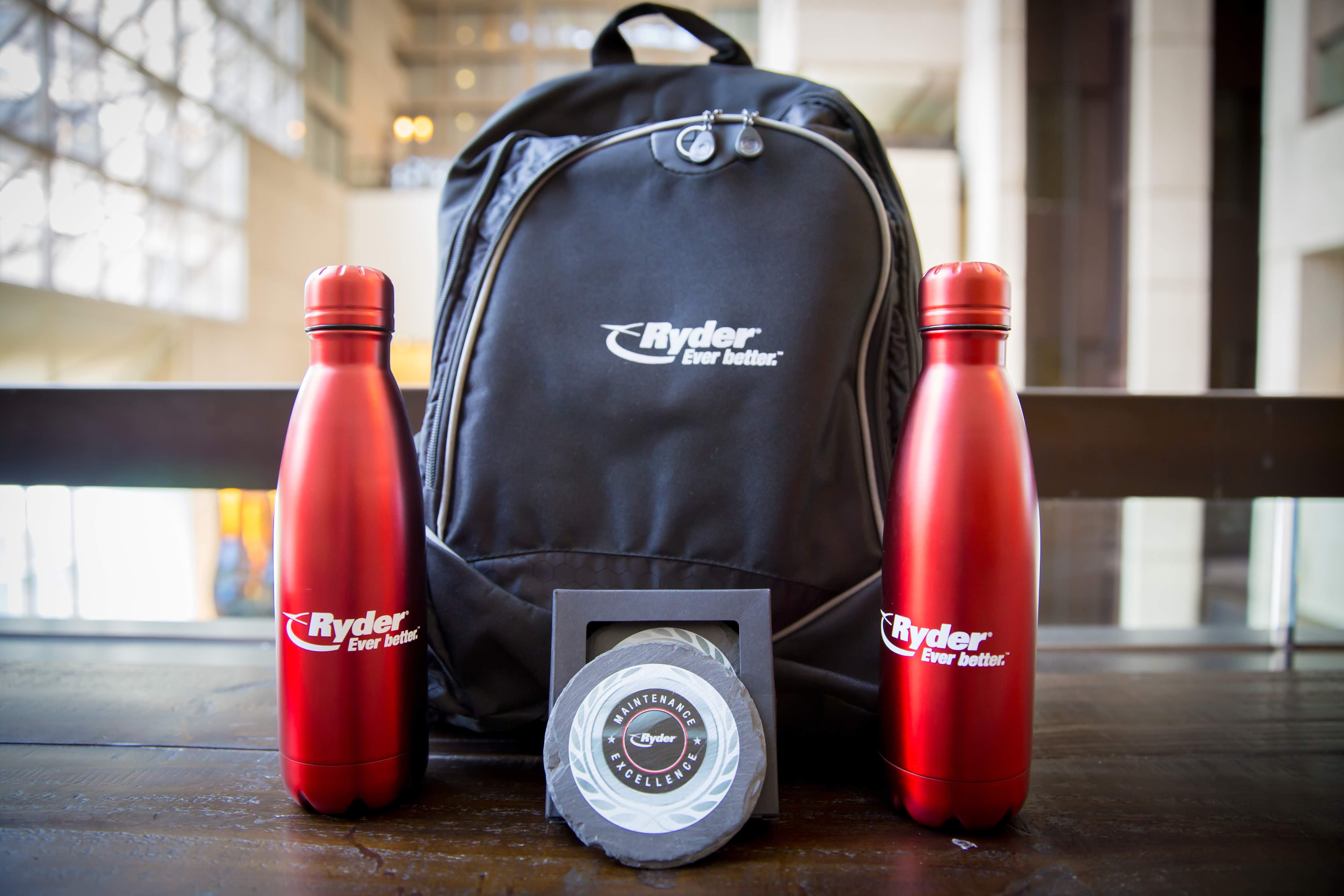 branded backpack and water bottles sitting on a table for corporate event gifting