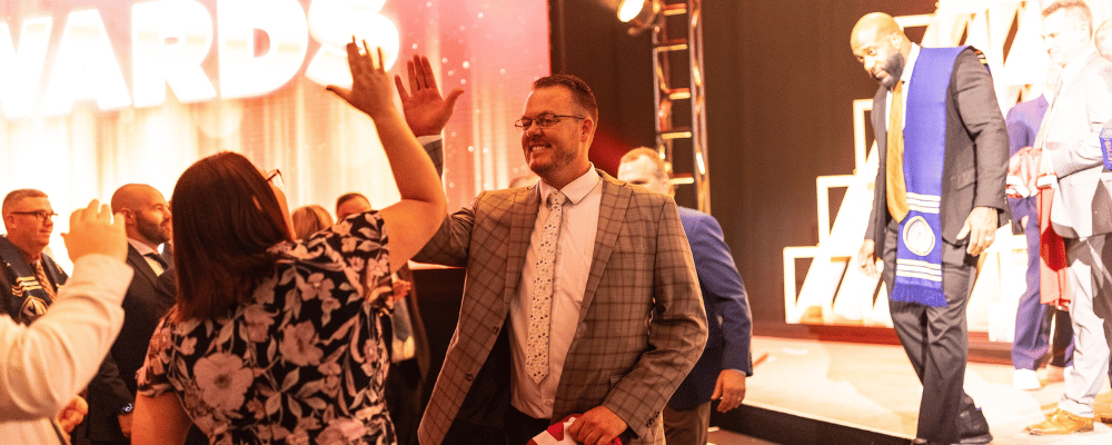 two attendees high fiving during an awards dinner