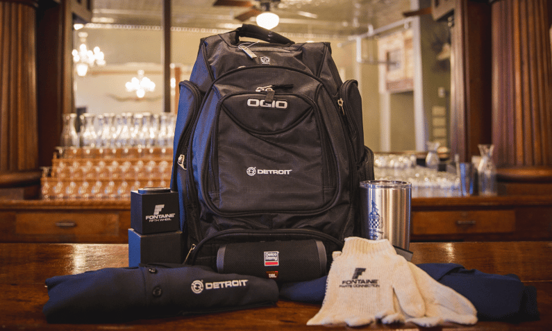 work backpack, tumbler, gloves, and shirt featuring different event logos