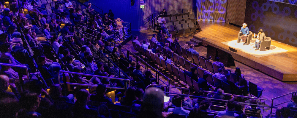 group of attendees watching two speakers presenting