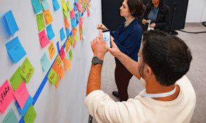 man at a global leadership meeting writing notes