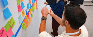 man writing a sticky note during a leadership meeting