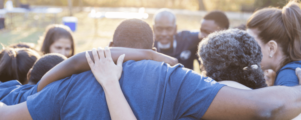 group of people participating in a give back activity by hugging