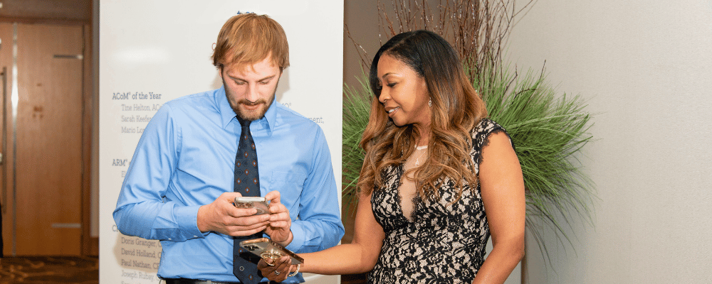 two attendees networking using their cell phones