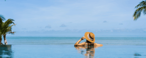 woman in a pool looking over ocean at an incentive trip