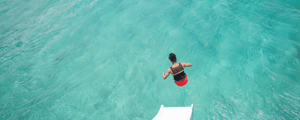 man jumping off slide into water