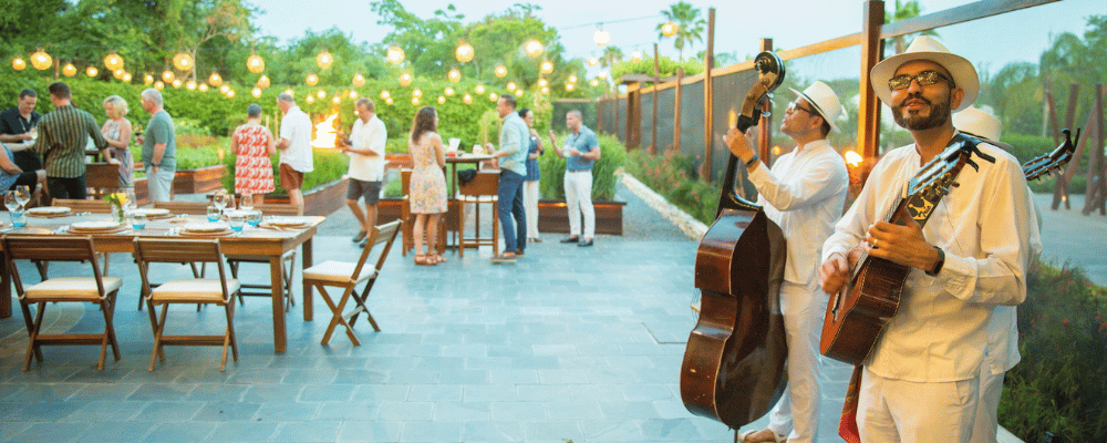 two men playing musical instruments at an event dinner in mexico