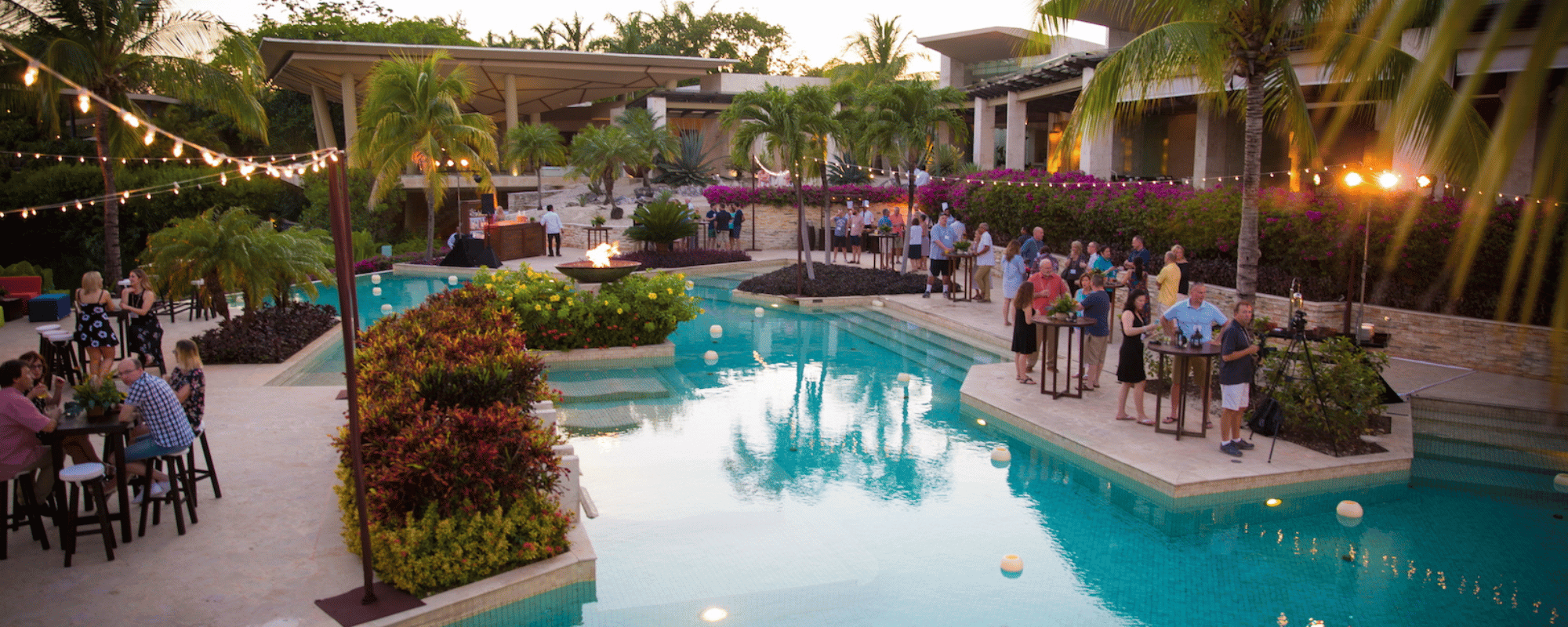 various people enjoying networking during incentive travel at a resort pool