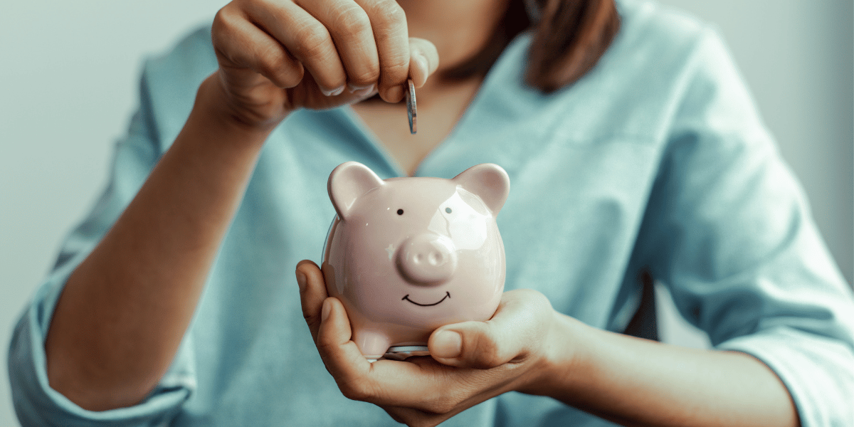 woman putting money in a piggy bank 