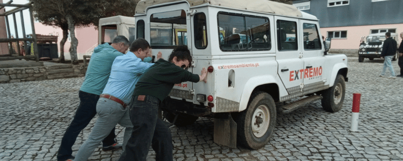 jeep being pushed by attendees for an extreme team building activity